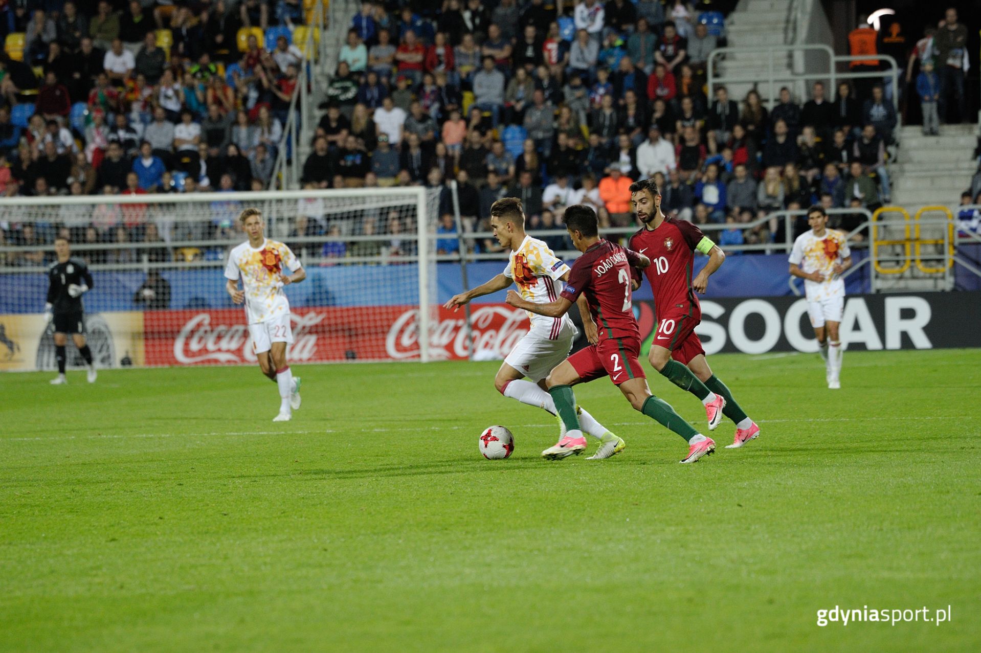 Sytuacja w trakcie meczu - dwóch piłkarzy Portugalii próbuje odebrać piłkę Hiszpanowi.