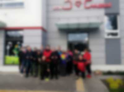 grupa ludzi z kijami przed treningiem nordic walking na Małym Kacku pod budynkiem z napisem Dom Marzeń
